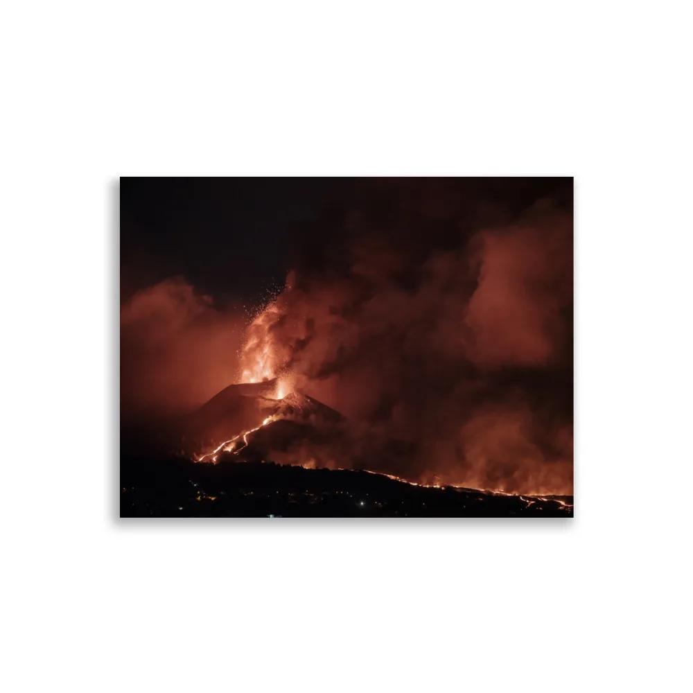 El "Póster volcán 2021 La Palma noche" presenta una erupción volcánica de color rojo anaranjado en La Palma por la noche, mostrando lava cayendo en cascada por la ladera de la montaña y densas columnas de humo ascendiendo hacia el cielo oscuro.