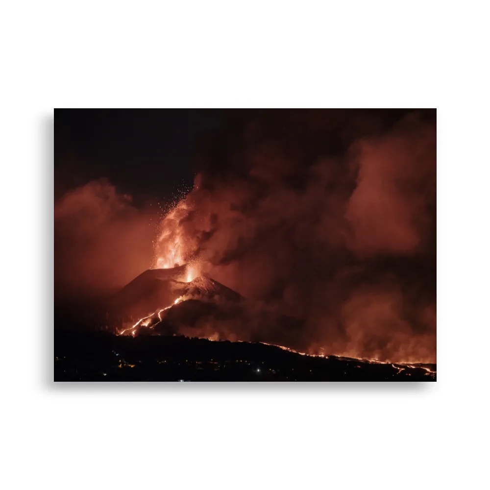 Bajo el cielo nocturno, el Póster volcán 2021 La Palma noche captura una erupción volcánica con lava y cenizas de color naranja intenso que iluminan la oscuridad. Corrientes de lava brillante caen en cascada por las laderas de las montañas entre nubes de humo y fuego, creando una escena fascinante que refleja la belleza de los encantadores Paisajes Canarios.