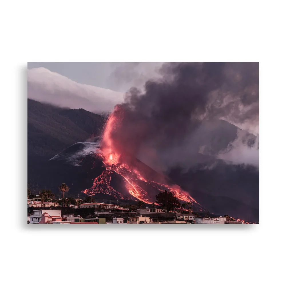 Una escena cautivadora de la erupción de un volcán en La Palma presenta ríos de lava resplandecientes y humo oscuro que se eleva hacia el cielo. La silueta de un pueblo en primer plano agrega profundidad a esta imagen impactante, ideal para quienes buscan un "Póster volcán 2021 La Palma edificios" espectacular o arte decorativo único para su espacio.