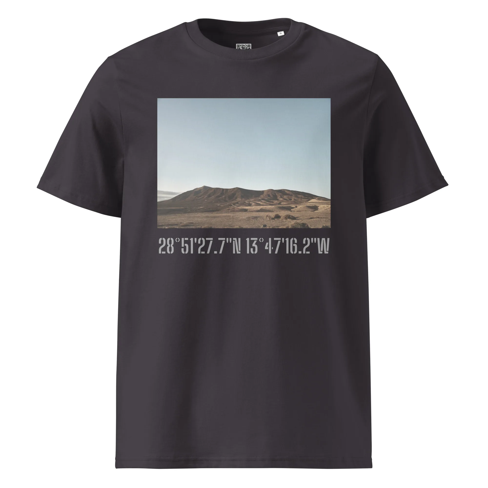 La camiseta unisex Los Ajaches de Volcanica Productions presenta una impresionante imagen de Paisajes Canarios de colinas bajo un cielo azul claro. Un elegante texto blanco debajo de la escena muestra las coordenadas geográficas: 28°5127.7N 13°4716.2W, disponible ahora en nuestra Tienda Online.