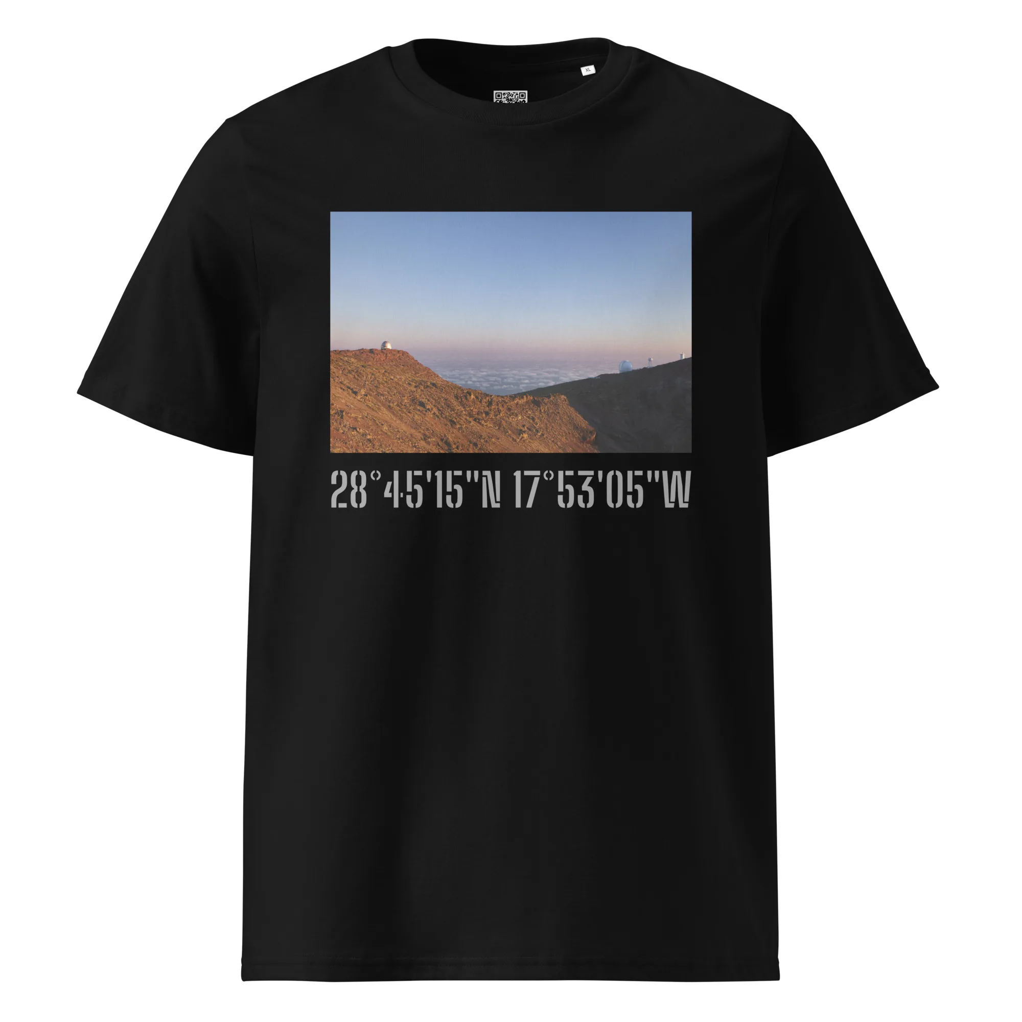 Camiseta negra con el nombre "Camiseta unisex Telescopios del Roque de los Muchachos" que muestra una impresionante fotografía de un paisaje montañoso bajo un cielo despejado, con el mar visible a lo lejos. Debajo de la imagen se muestran las coordenadas geográficas: 28° 45' 15" N 17° 53' 05" W, con impresionantes Paisajes Canarios de La Palma como fotografías impresas.
