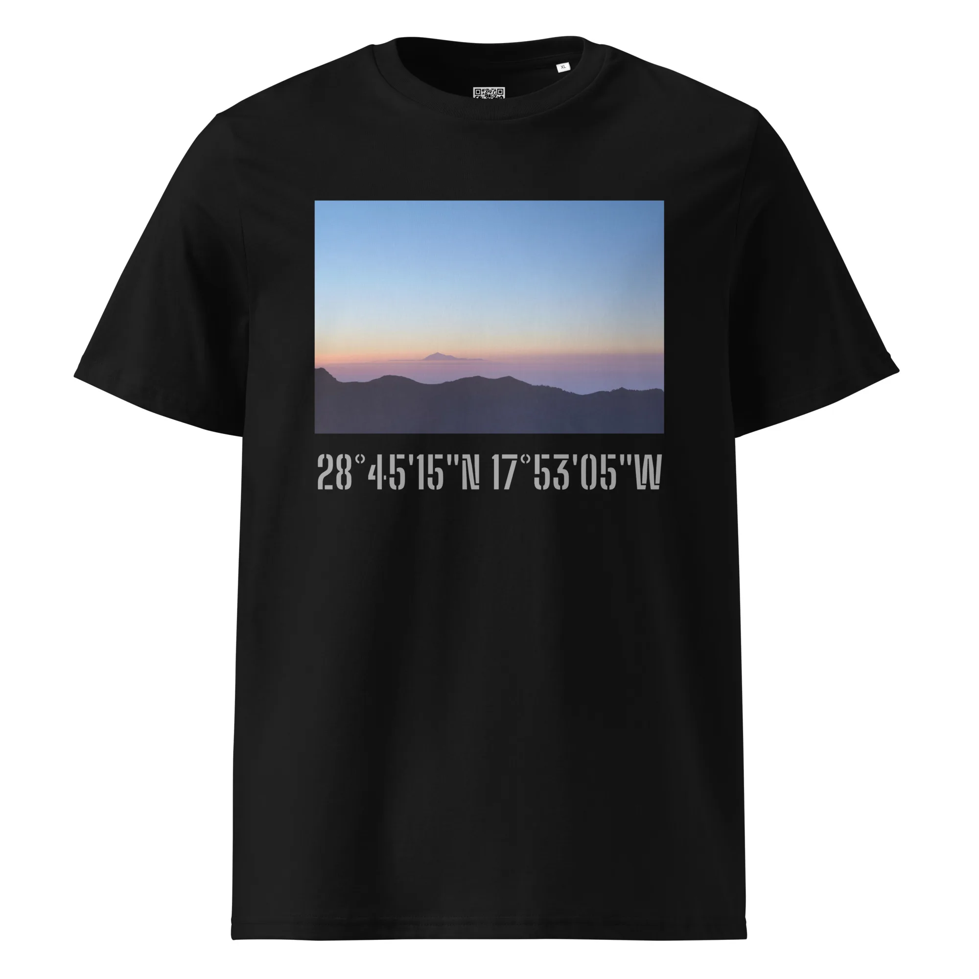 La camiseta unisex "Amanecer desde el Roque de los Muchachos" de Volcanica Productions es una camiseta negra que muestra una impresionante imagen de un atardecer con siluetas de montañas. Debajo de la fotografía, se muestran en blanco las coordenadas geográficas: 28°4515N 17°5305W, capturando la esencia de La Palma.