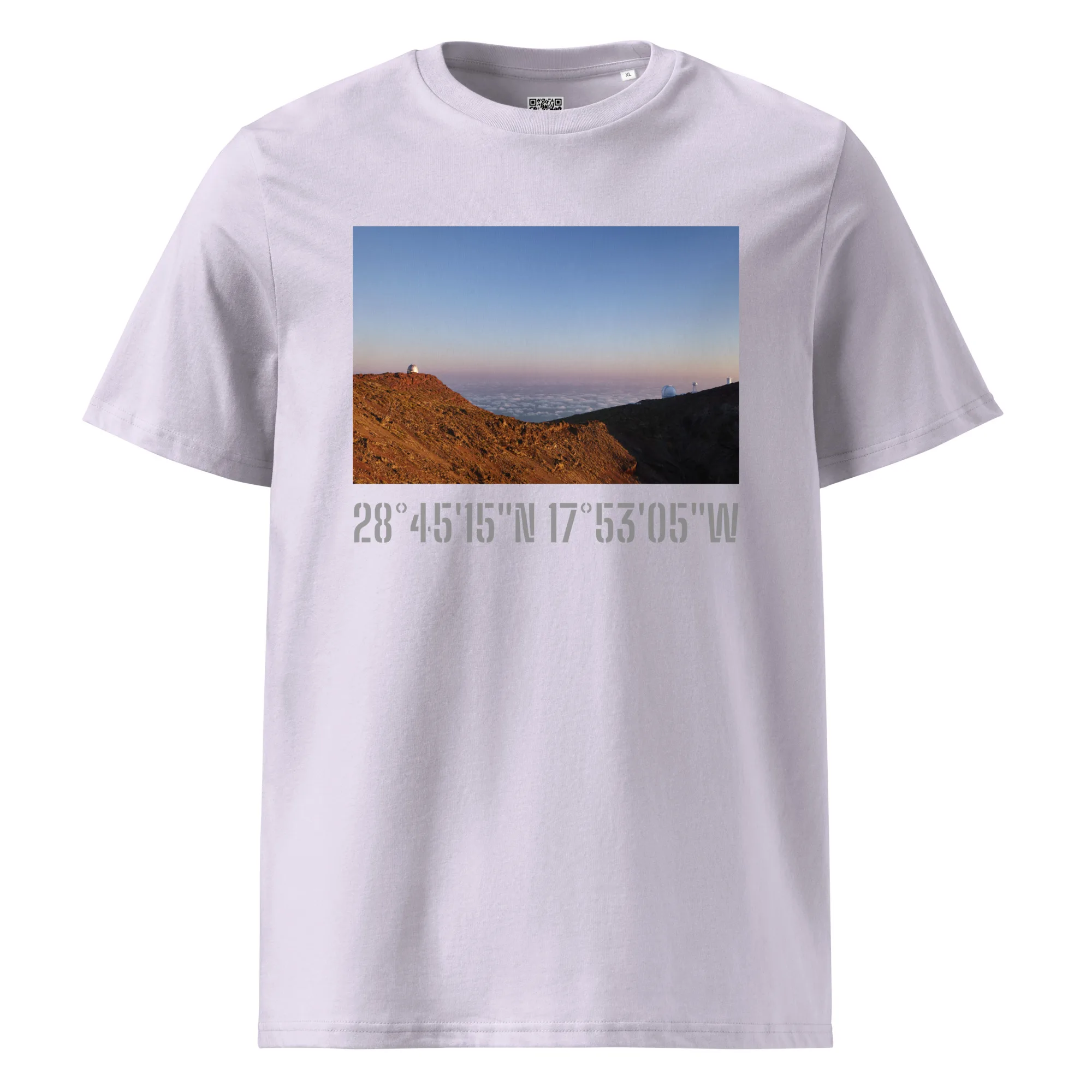 La camiseta unisex Telescopios del Roque de los Muchachos de Volcanica Productions es una camiseta gris claro que muestra un paisaje montañoso escénico con un cielo azul arriba y un terreno rocoso abajo. Debajo de la imagen, las coordenadas 28° 45' 15'' N 17° 53' 05'' W están escritas con negrita, capturando la esencia del Arte Decorativo.